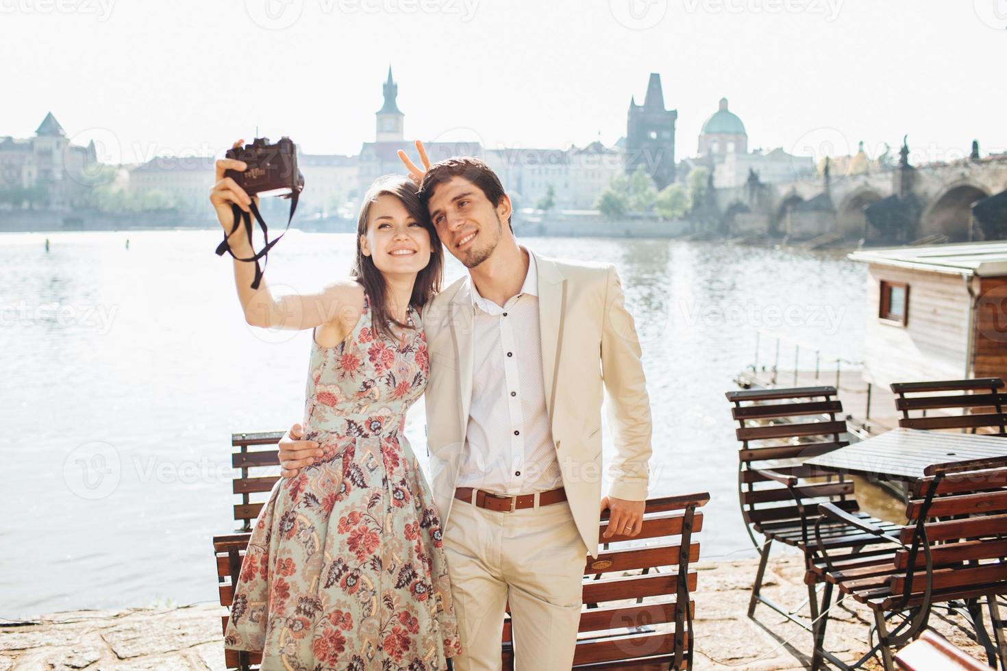 buitenopname van gelukkige vrouw en man omhelzen elkaar en poseren voor het maken van selfie, wandelen in de buurt van een prachtig landschap, in een goed humeur zijn, genieten van mooi weer. mensen en vrije tijd concept foto