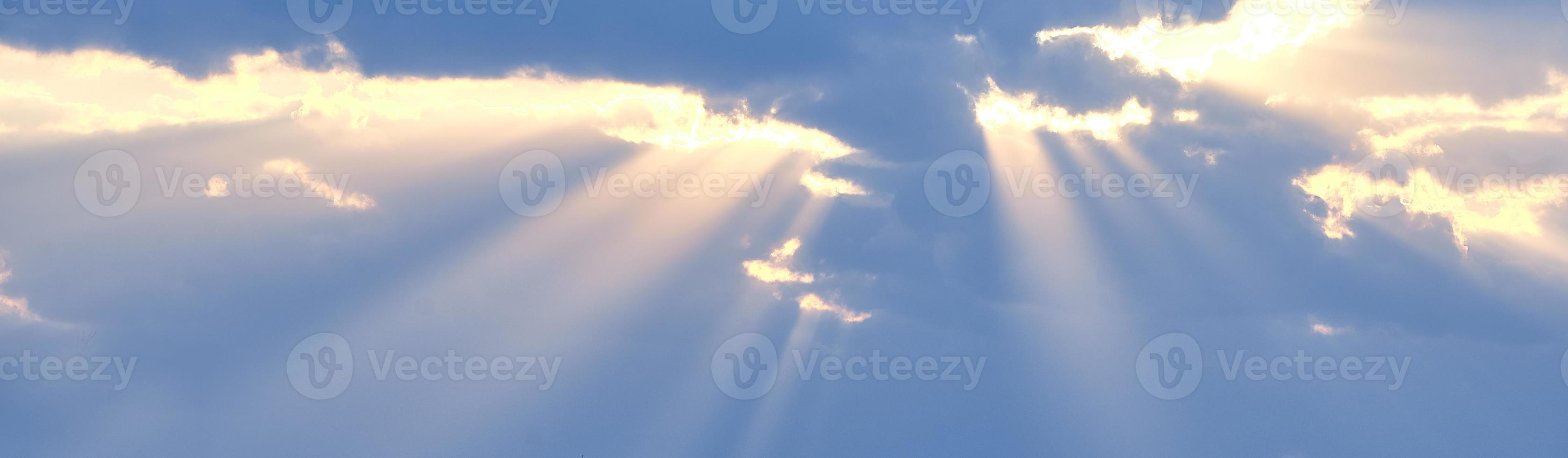 de zonnestralen breken door de blauwe wolken. de achtergrond van de hemel. foto
