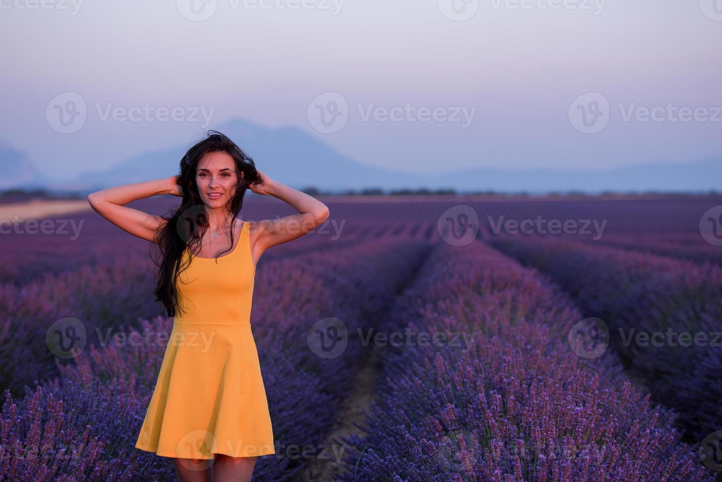 vrouw in gele jurk bij lavendelveld foto
