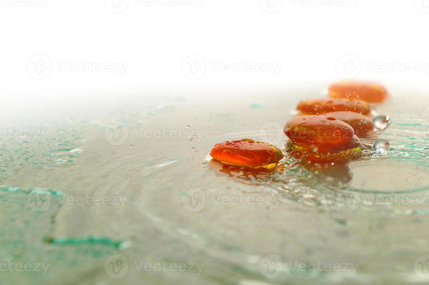 geïsoleerde natte zen-stenen met opspattende waterdruppels foto