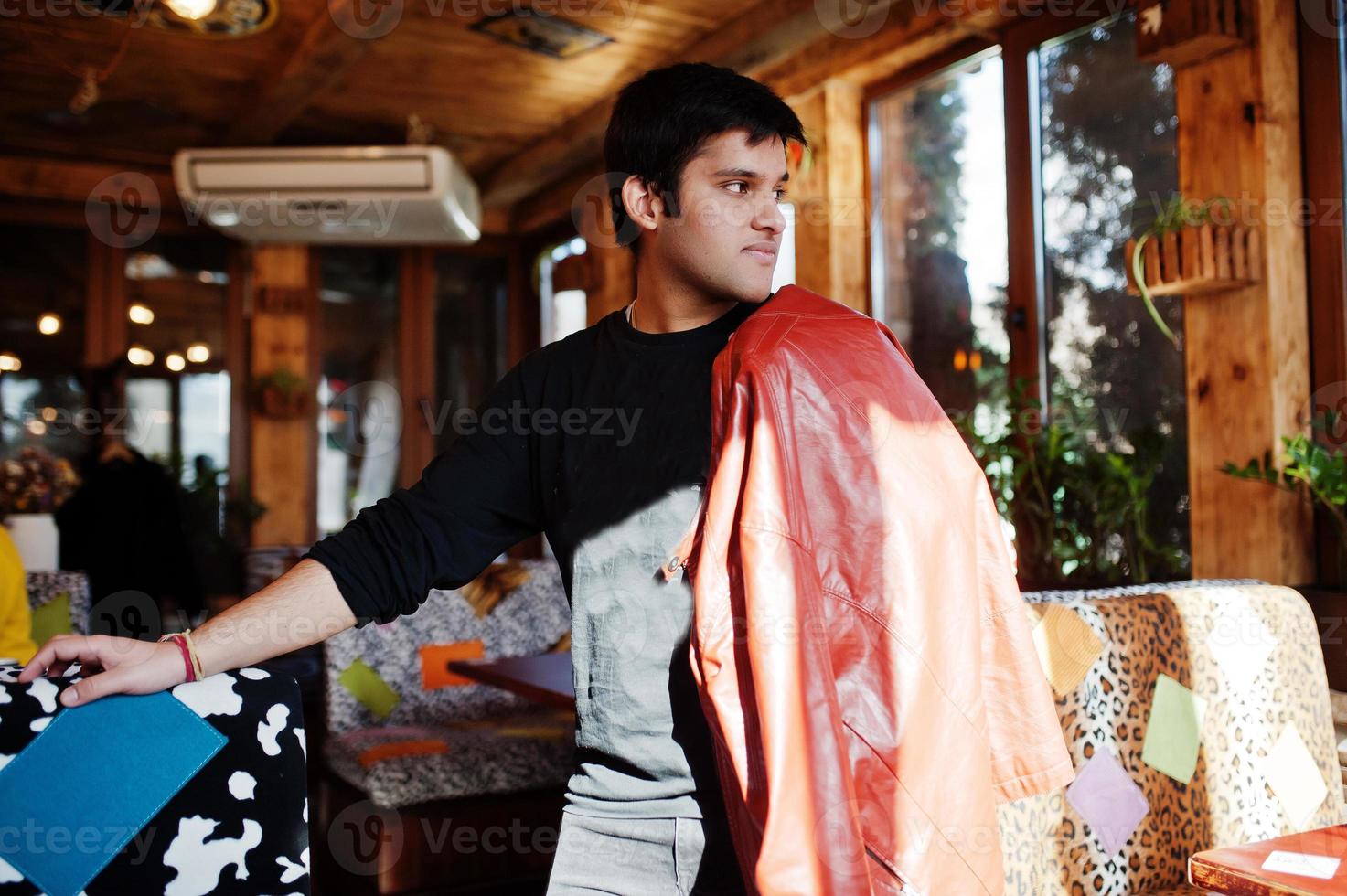 stijlvolle Indiase man in vrijetijdskleding poseren indoor café. foto