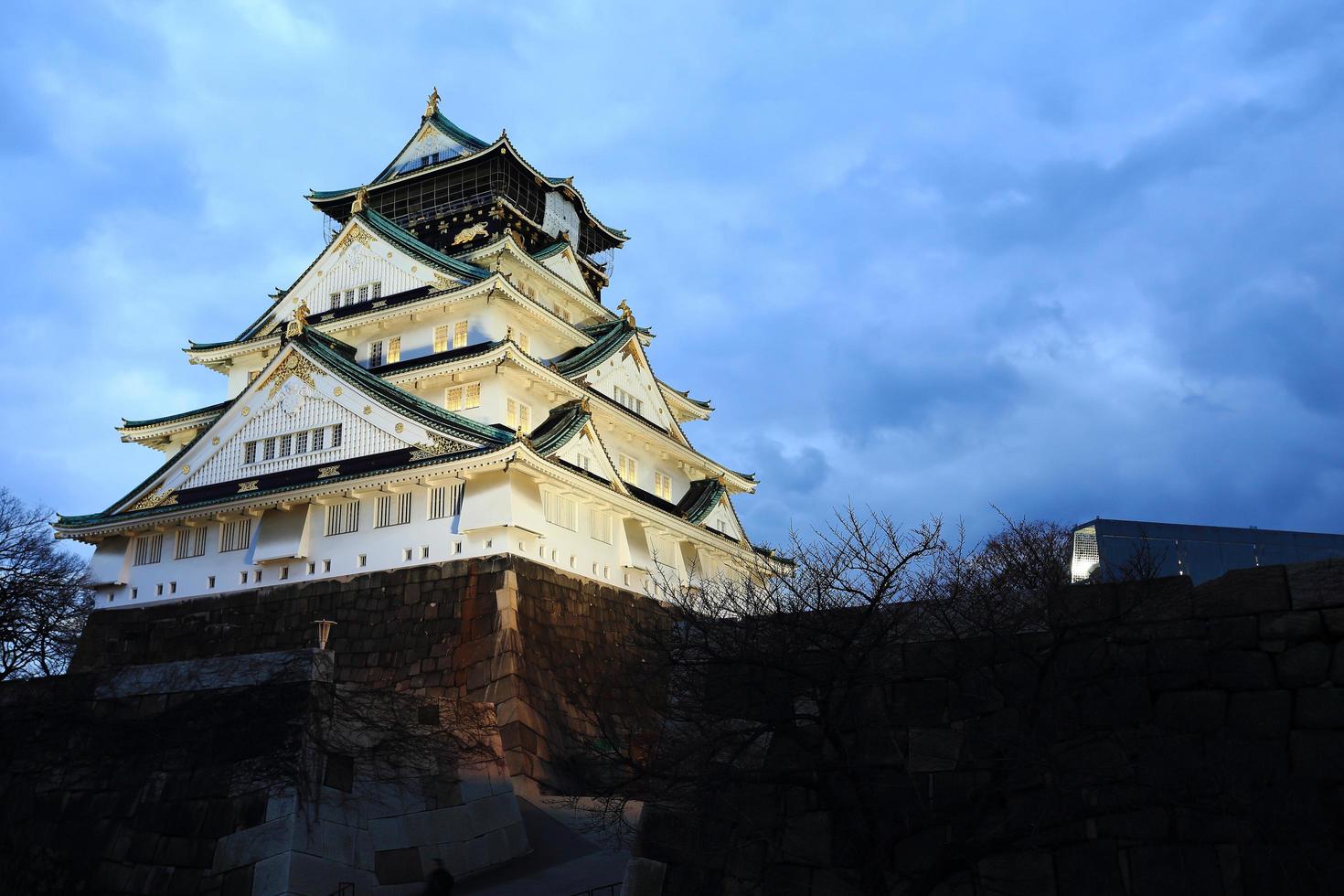 osaka kasteel in osaka, japan verlicht door schijnwerpers tijdens de schemering. foto