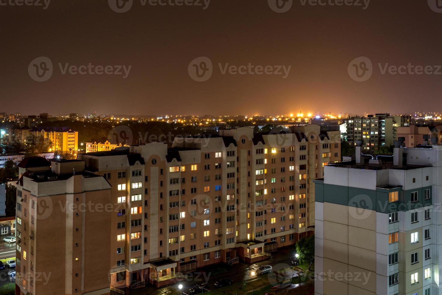 nachtpanorama van licht in de ramen van een gebouw met meerdere verdiepingen. leven in een grote stad foto