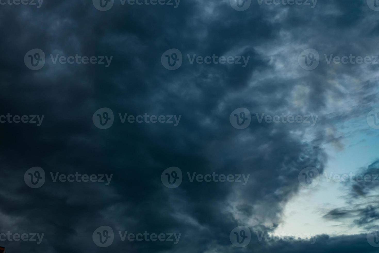 donkerblauwe hemelachtergrond met avond pluizige krullende rollende altocumulus altostratus wolken foto
