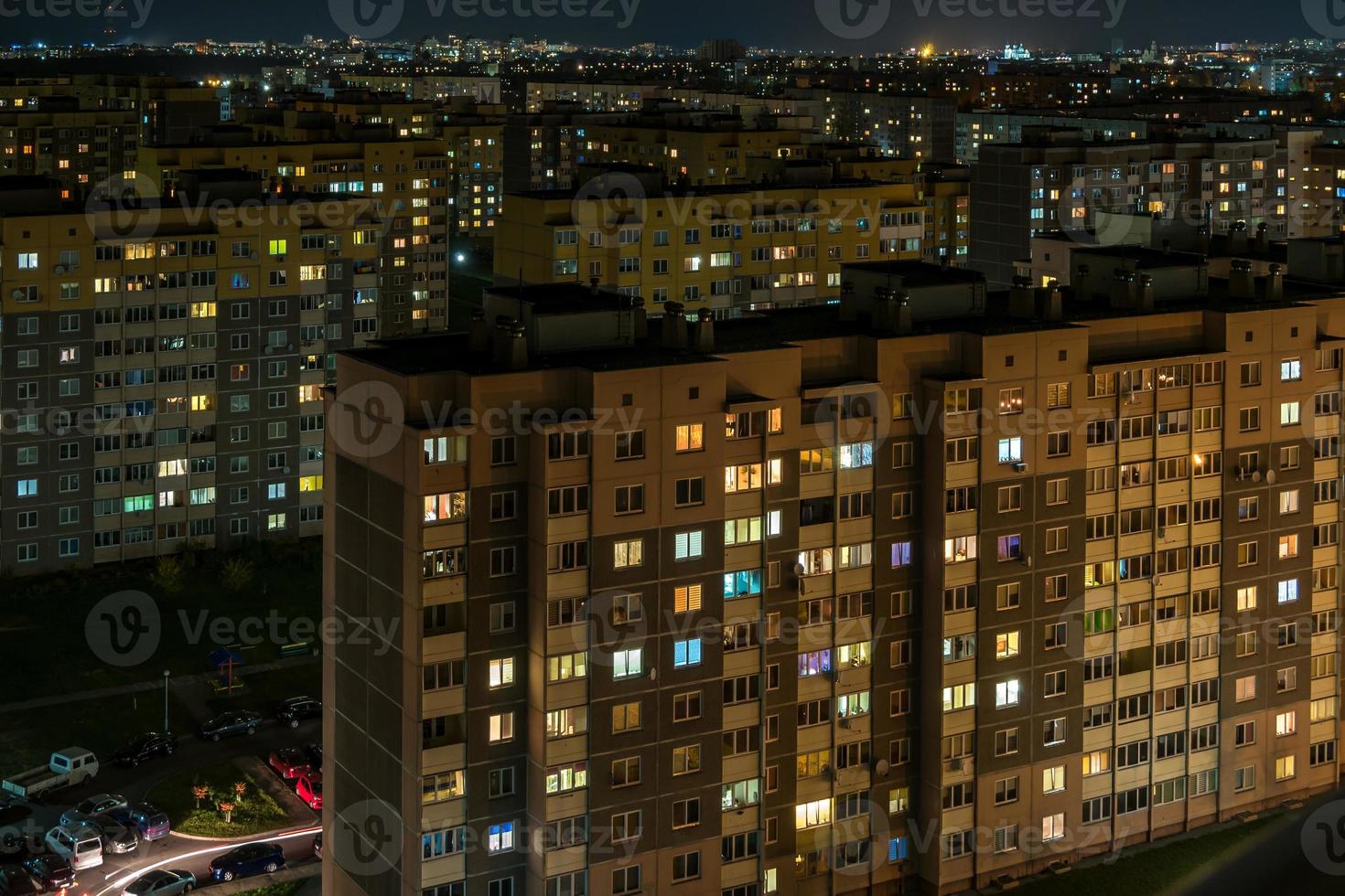 nachtpanorama van licht in de ramen van een gebouw met meerdere verdiepingen. leven in een grote stad foto