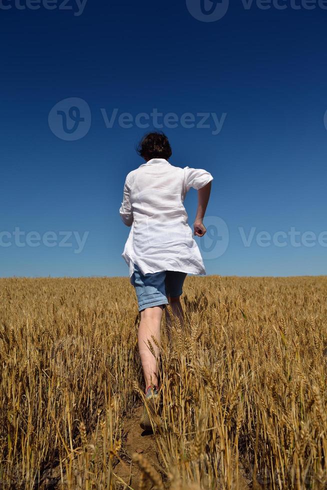 jonge vrouw in tarweveld in de zomer foto