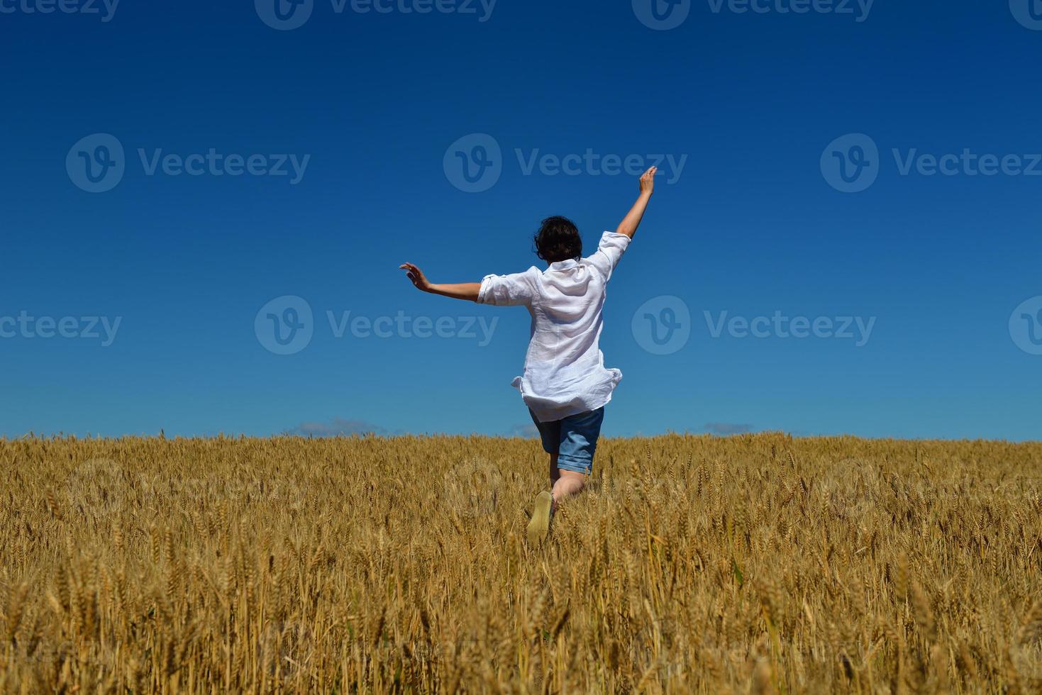 jonge vrouw in tarweveld in de zomer foto