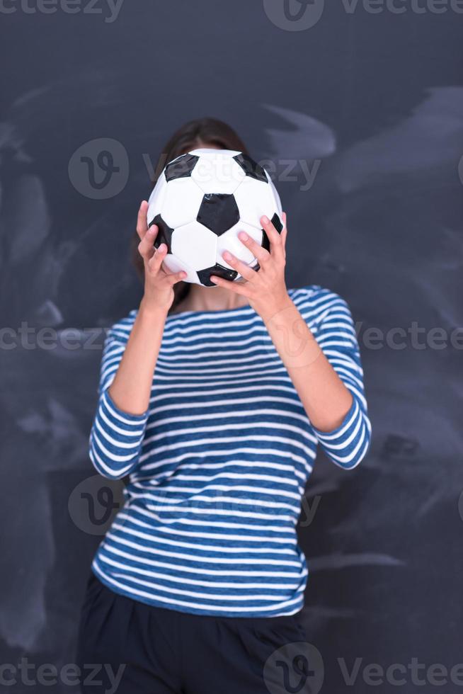 vrouw die een voetbal voor krijttekenbord houdt foto