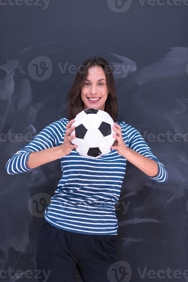 vrouw die een voetbal voor krijttekenbord houdt foto