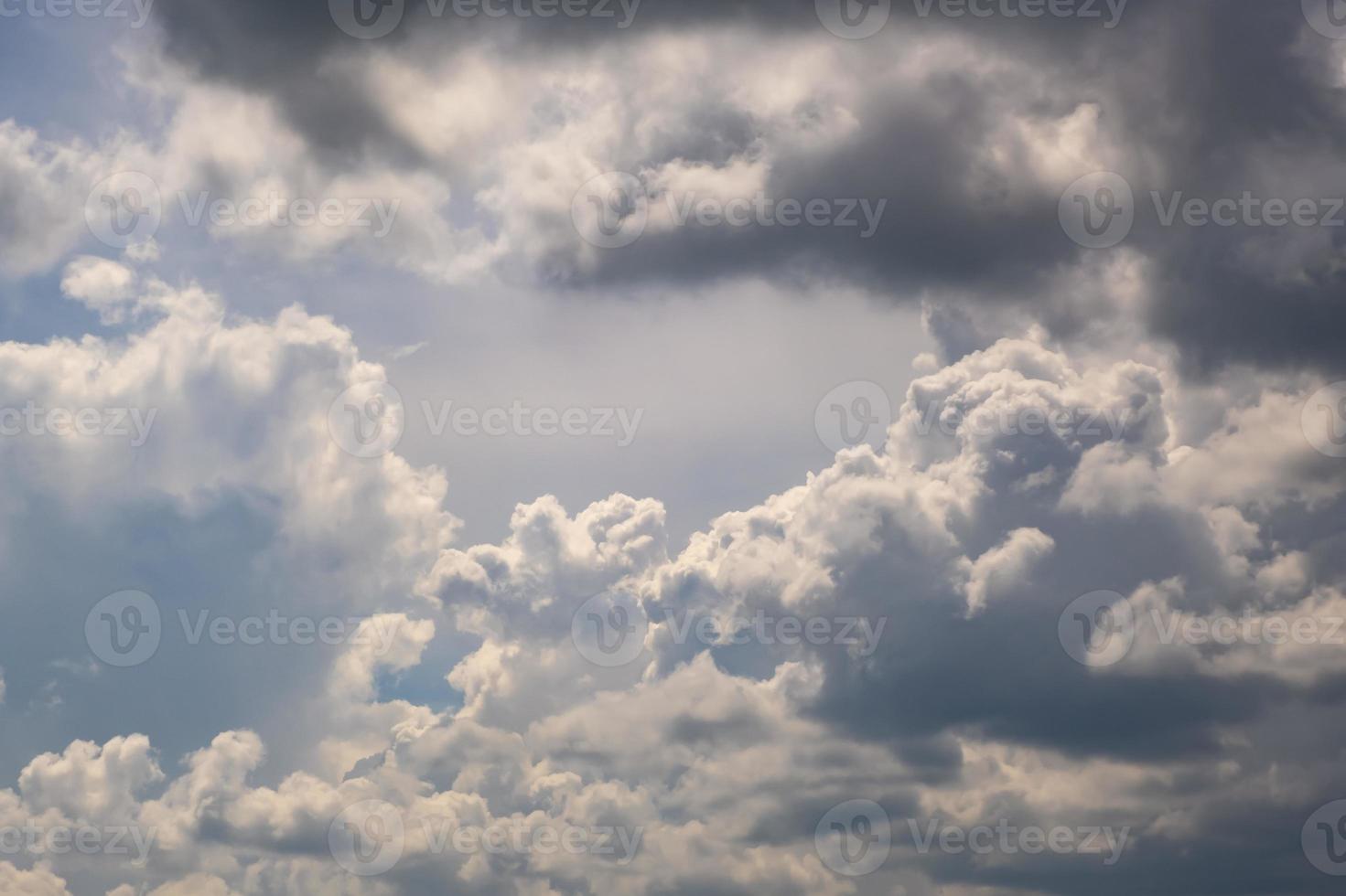 blauwe hemelachtergrond met grote witte kleine stratus cirrus gestreepte wolken foto