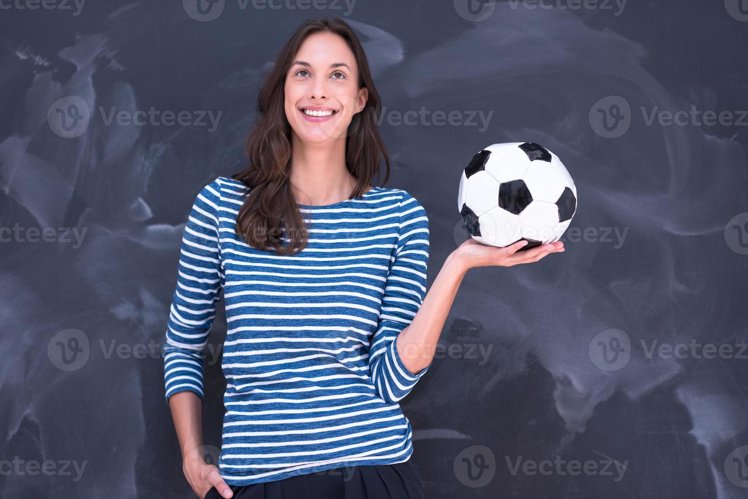 vrouw die een voetbal voor krijttekenbord houdt foto