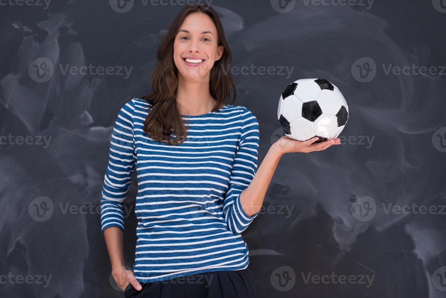 vrouw die een voetbal voor krijttekenbord houdt foto