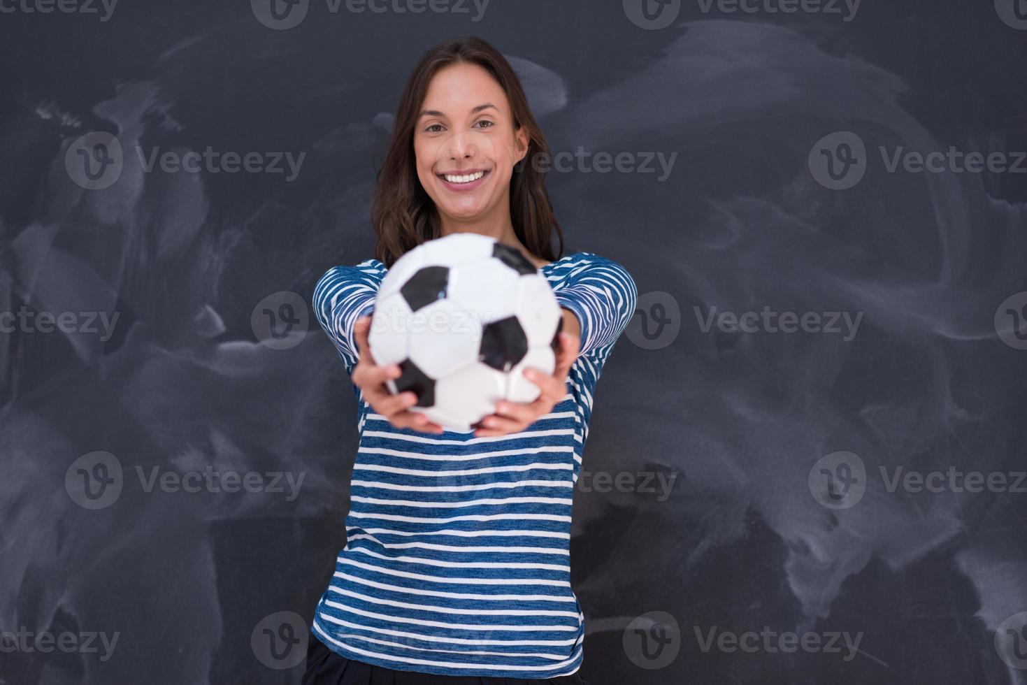 vrouw die een voetbal voor krijttekenbord houdt foto