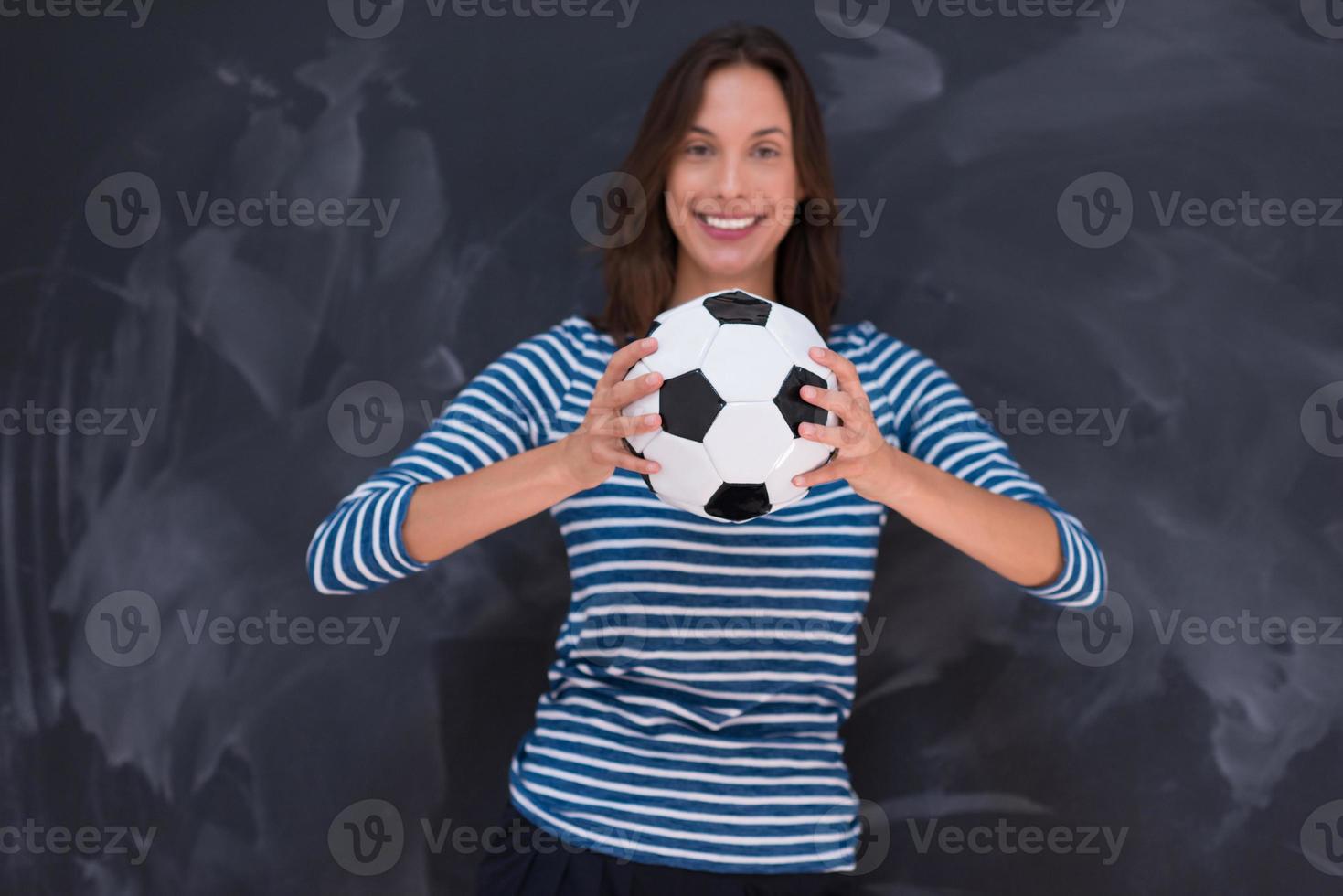 vrouw die een voetbal voor krijttekenbord houdt foto