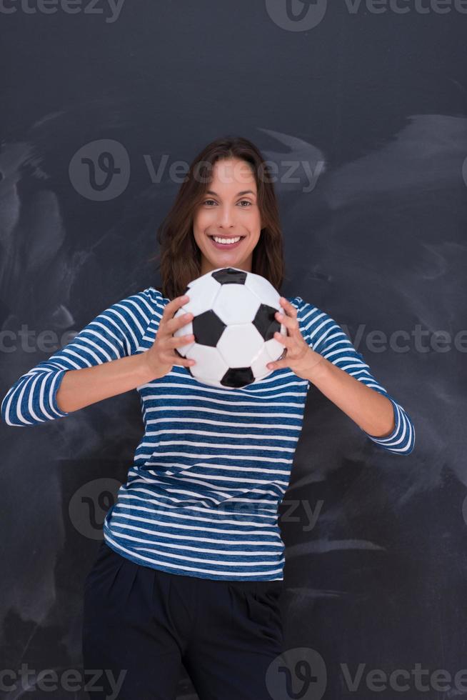 vrouw die een voetbal voor krijttekenbord houdt foto