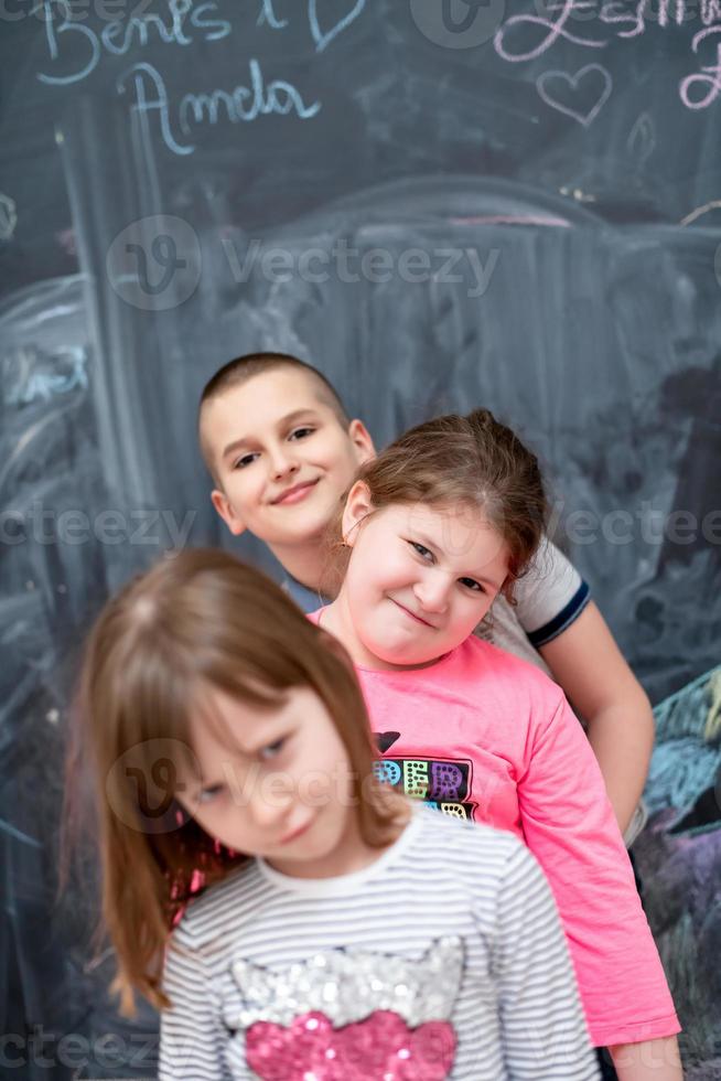 groep kinderen die voor schoolbord staan foto