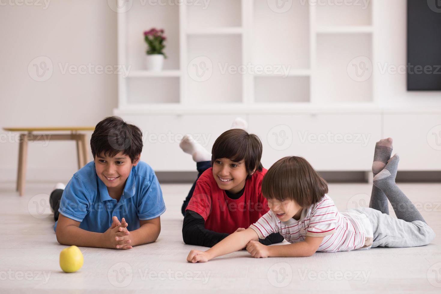 jongens die plezier hebben met een appel op de vloer foto