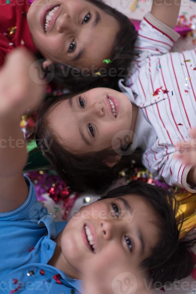 kinderen die confetti blazen terwijl ze op de grond liggen foto