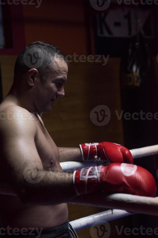 kickbokser rustend op de touwen in de hoek foto