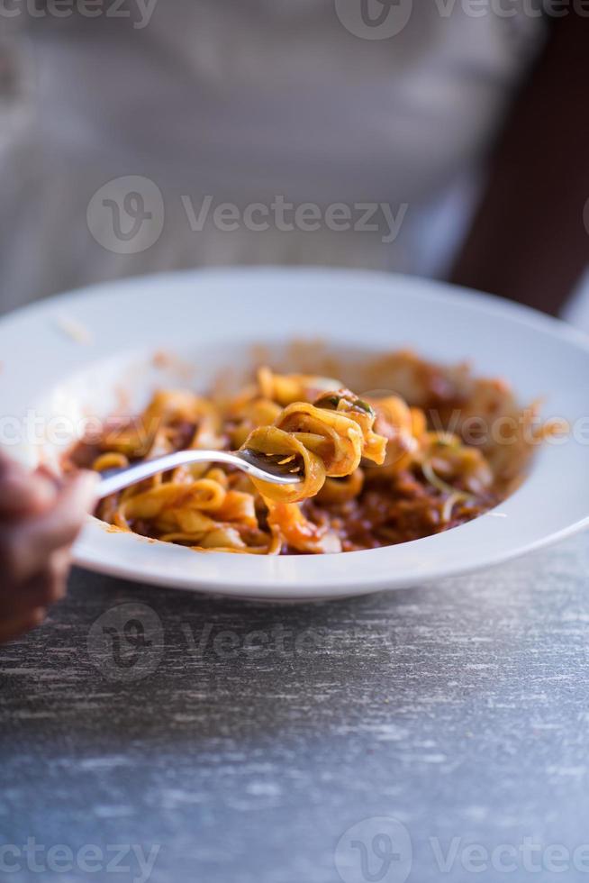 een jonge Afro-Amerikaanse vrouw die pasta eet foto