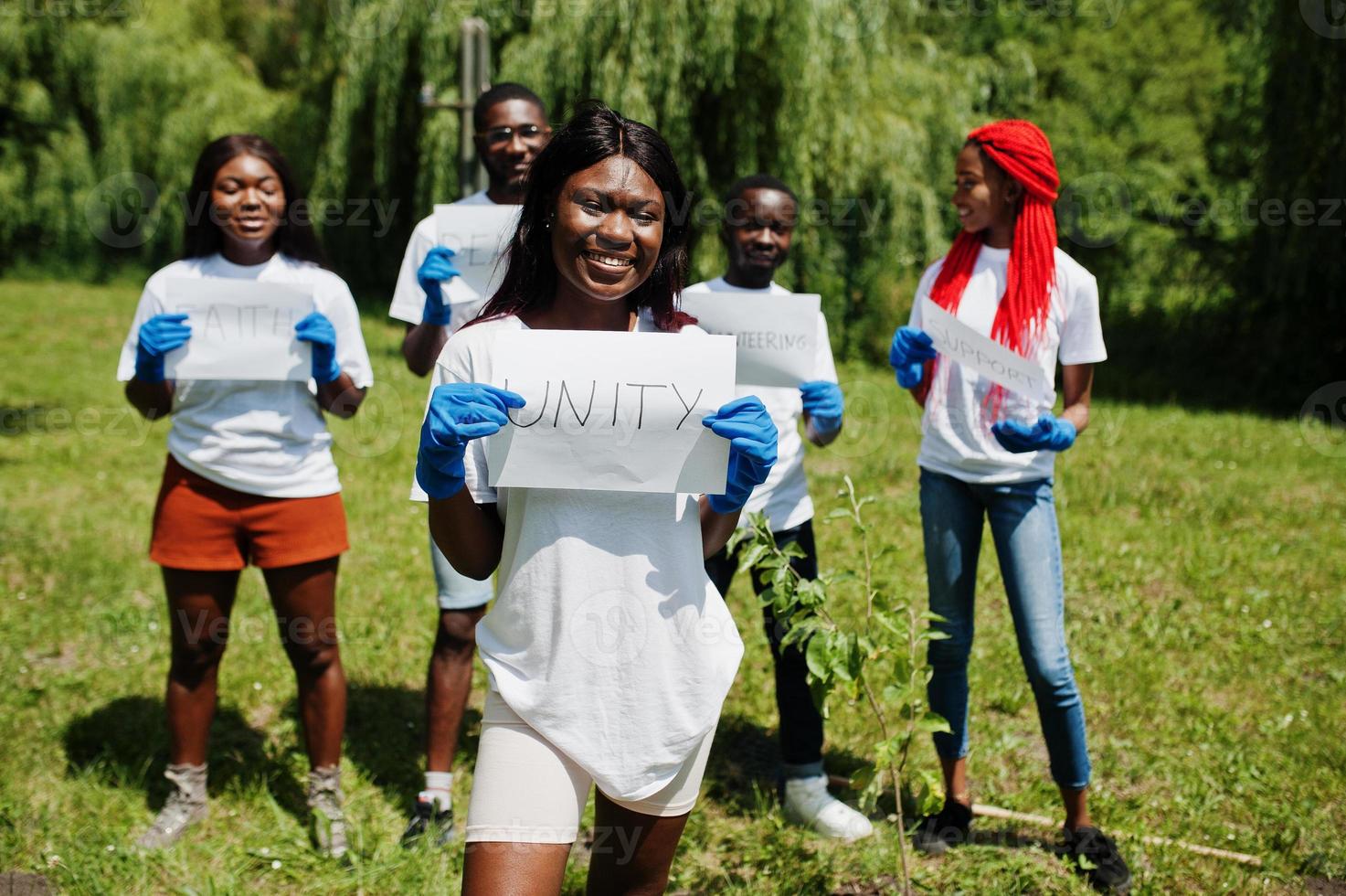 groep gelukkige afrikaanse vrijwilligers houdt een leeg bord met eenheidsbord in het park. Afrika vrijwilligerswerk, liefdadigheid, mensen en ecologie concept. foto