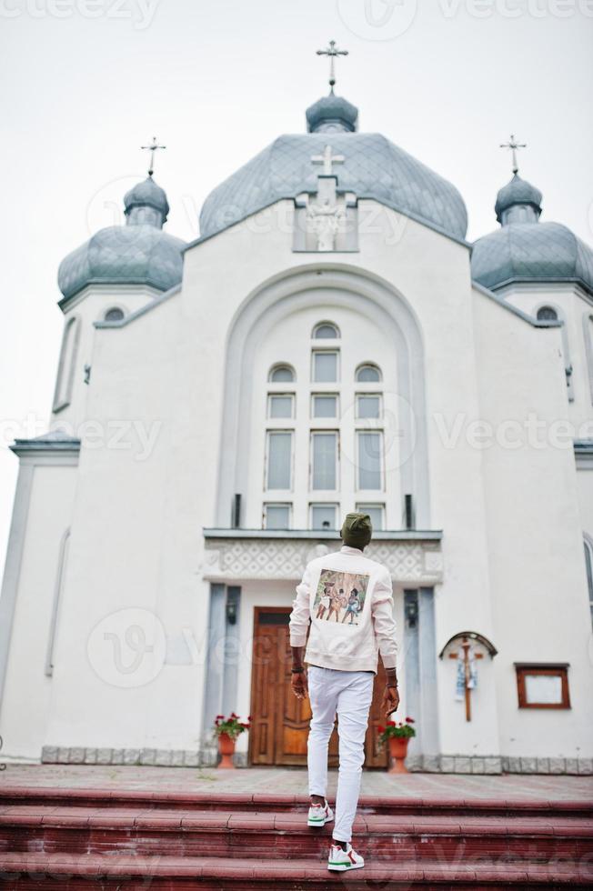 Afro-Amerikaanse man in hoed staan tegen kerk. geloof en christendom in afrika. foto