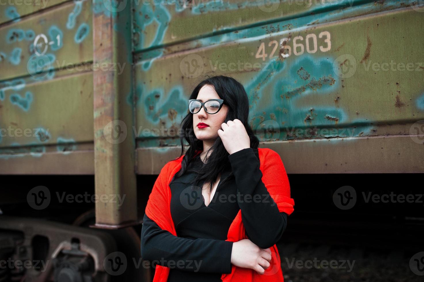 brunette meisje dragen in het zwart met een bril in treinstation. foto