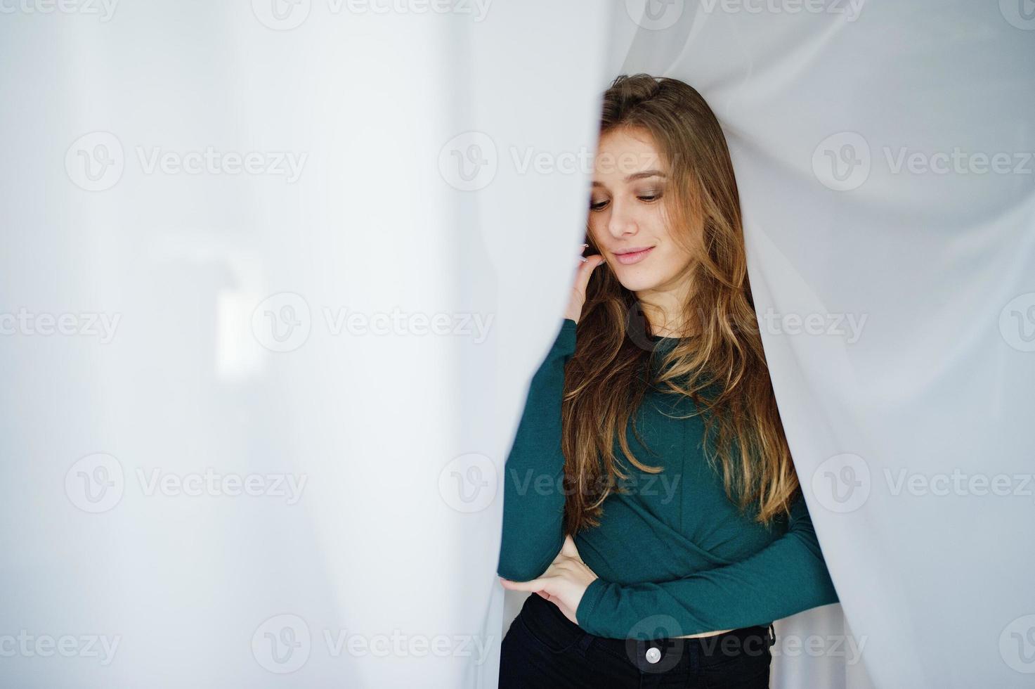 knappe brunette meisje slijtage op groen, poseren op gordijnen. studiomodel portret. foto