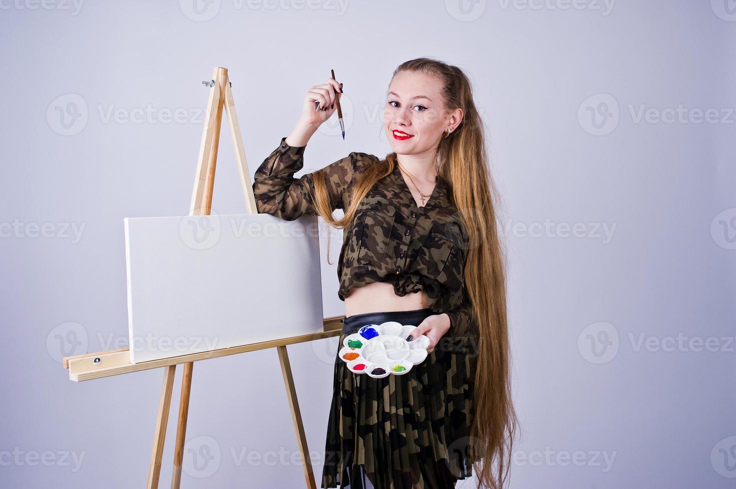 mooie vrouw kunstenaar schilder met borstels en olie canvas poseren in studio geïsoleerd op wit. foto