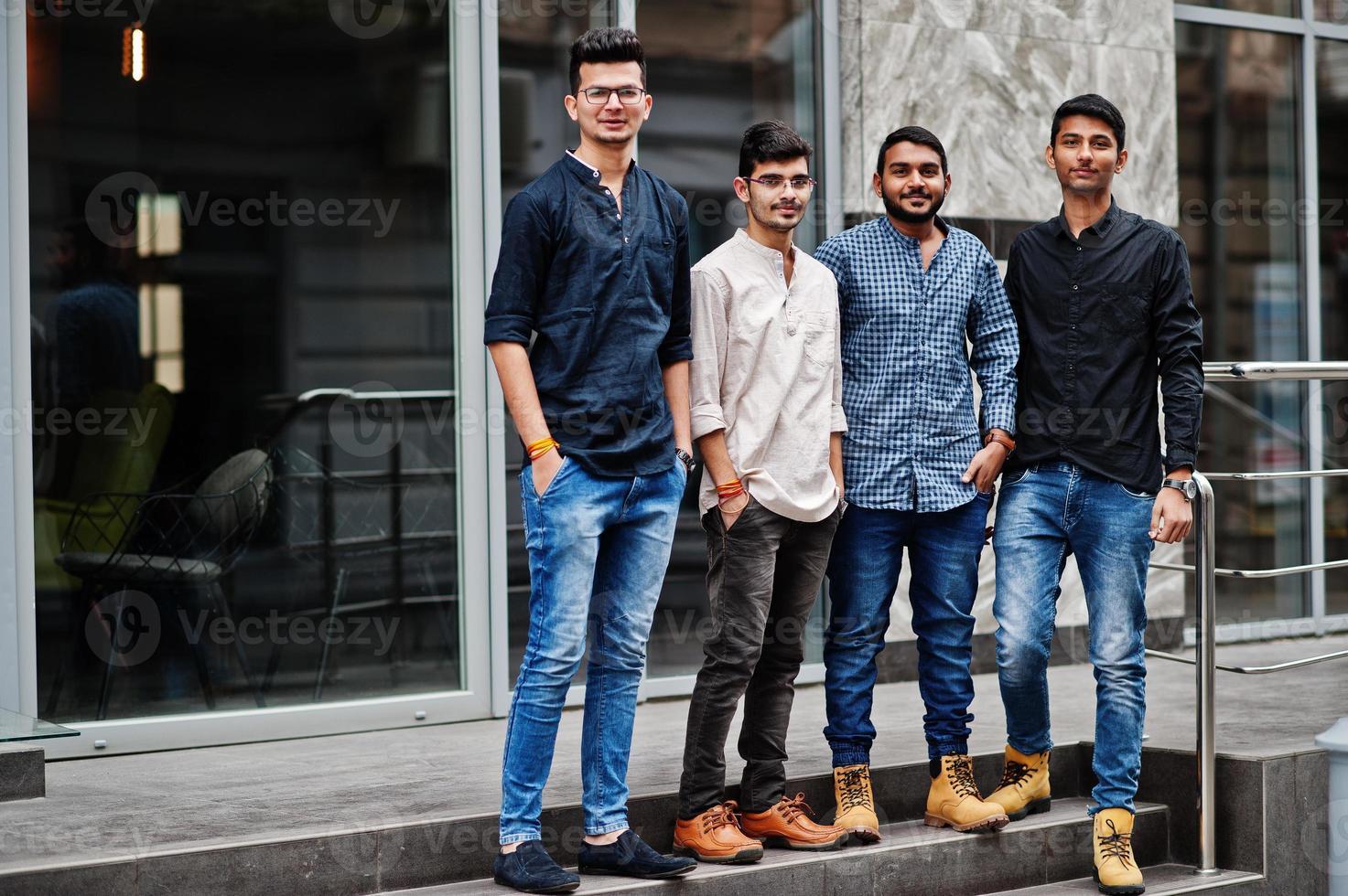 groep van vier indiase mans, draag vrijetijdskleding, poseerde buiten op straat in india. foto