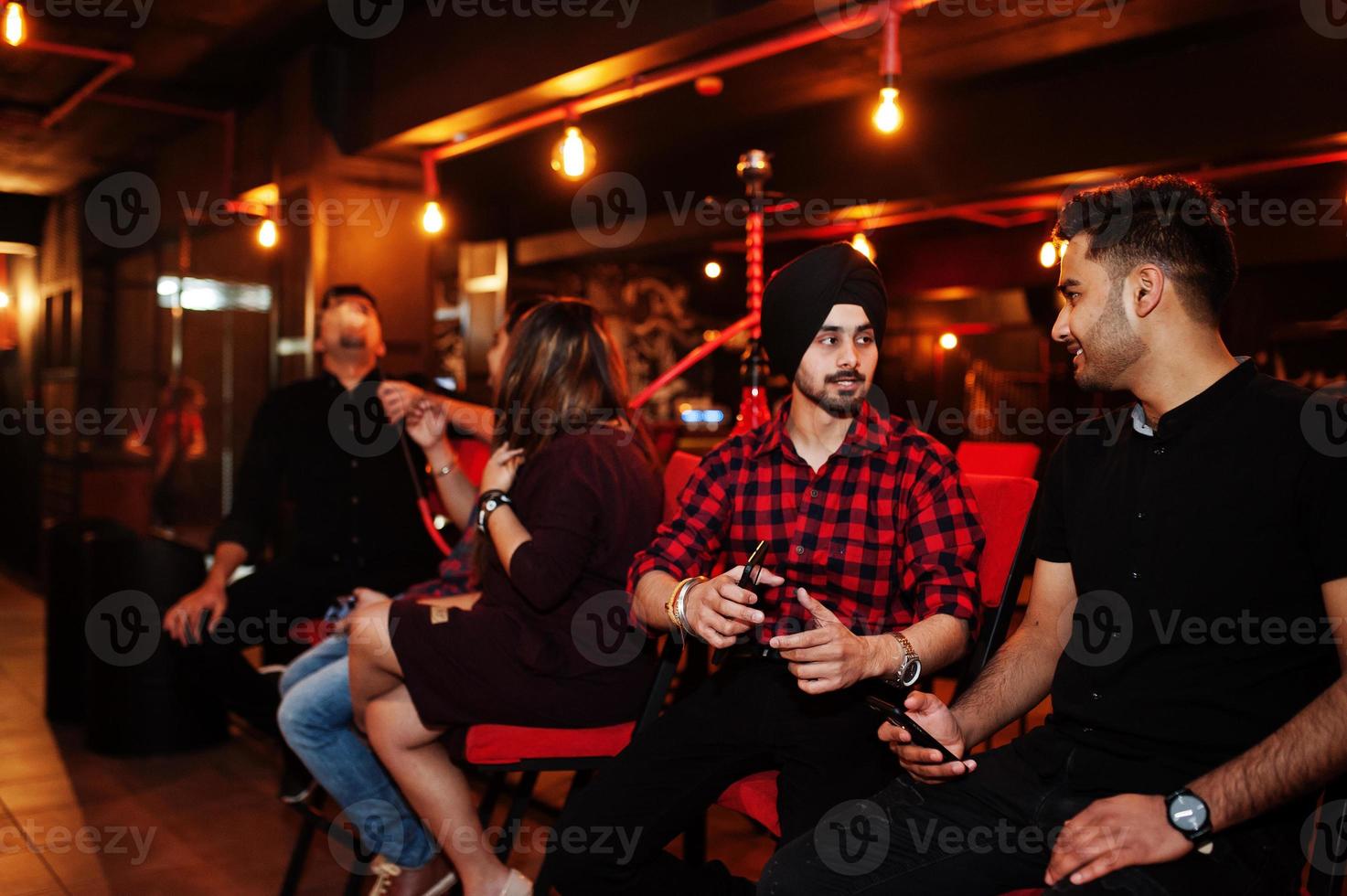 groep indische vrienden die aan de loungebar zitten, waterpijp roken en rusten. foto