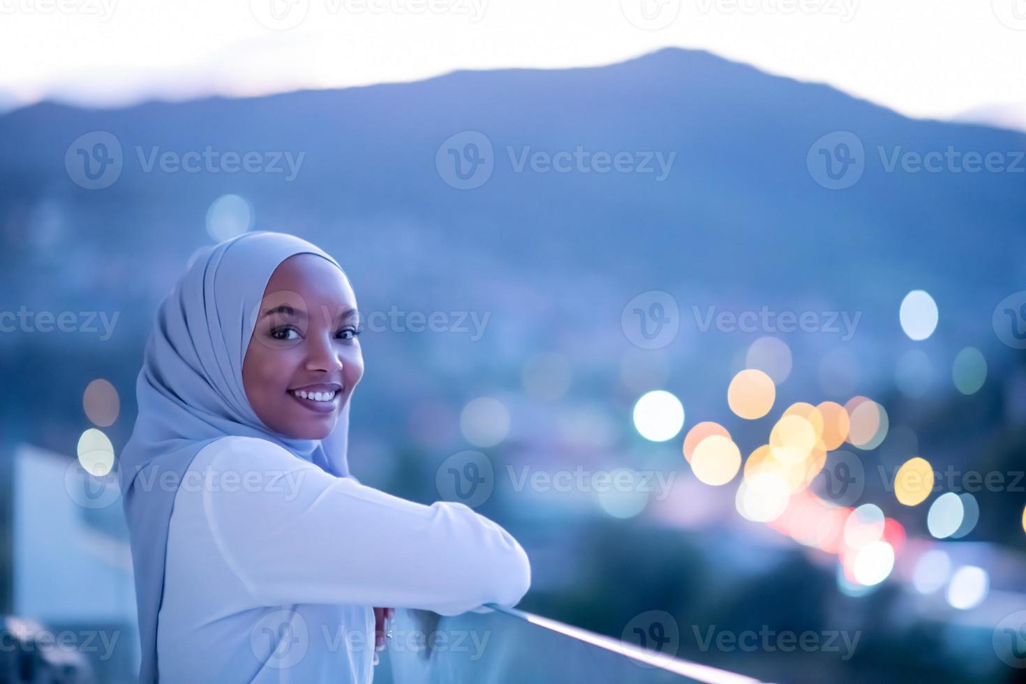 Afrikaanse moderne moslimvrouw in de nacht op het balkon foto