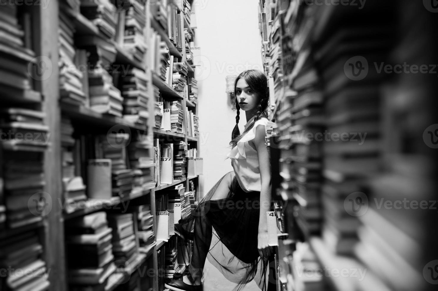 meisje met staartjes in witte blouse bij oude bibliotheek. foto