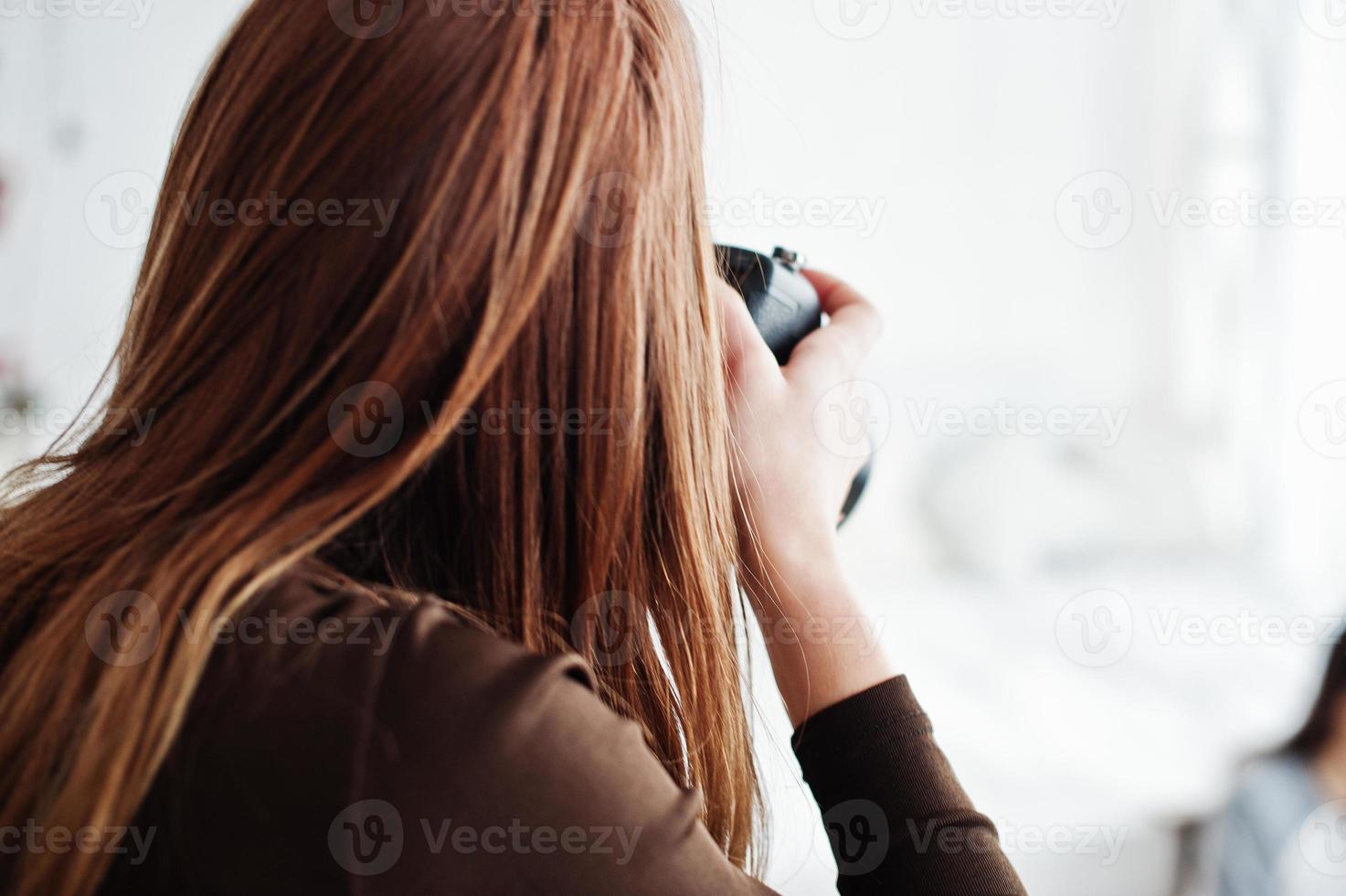 close-up achterkant van jonge meisje fotograaf schieten op studio. professionele fotograaf op het werk. foto