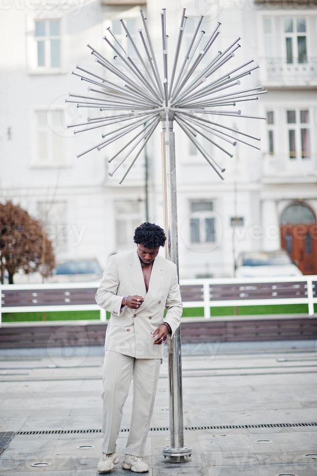 stijlvolle afro man in beige old school pak. modieuze jonge Afrikaanse man in casual jas op blote torso. foto