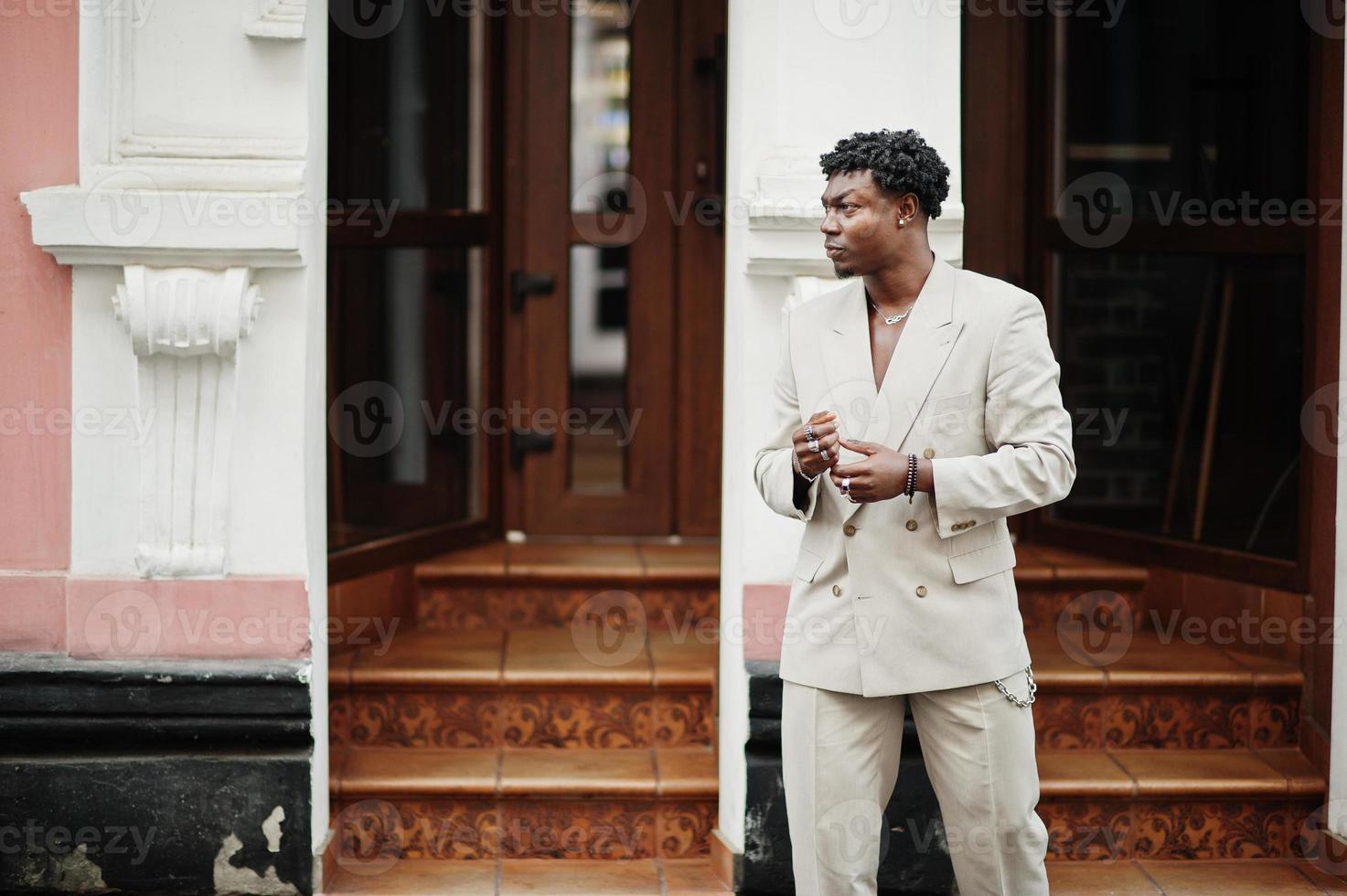 stijlvolle afro man in beige old school pak. modieuze jonge Afrikaanse man in casual jas op blote torso. foto