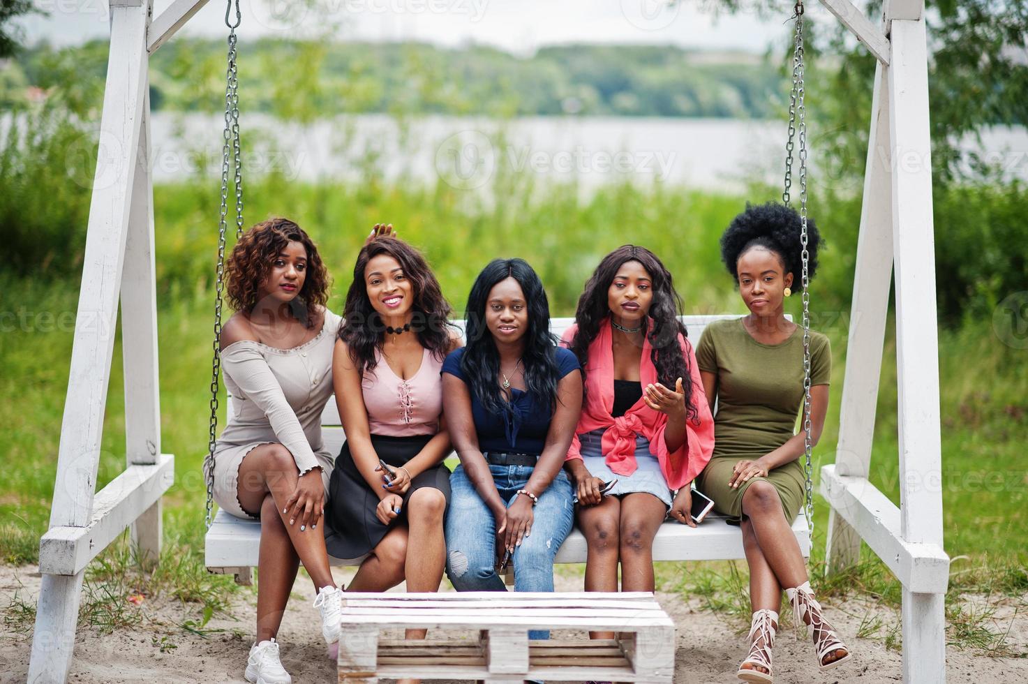 groep van vijf Afro-Amerikaanse meisjes ontspannen op mooie schommel. foto