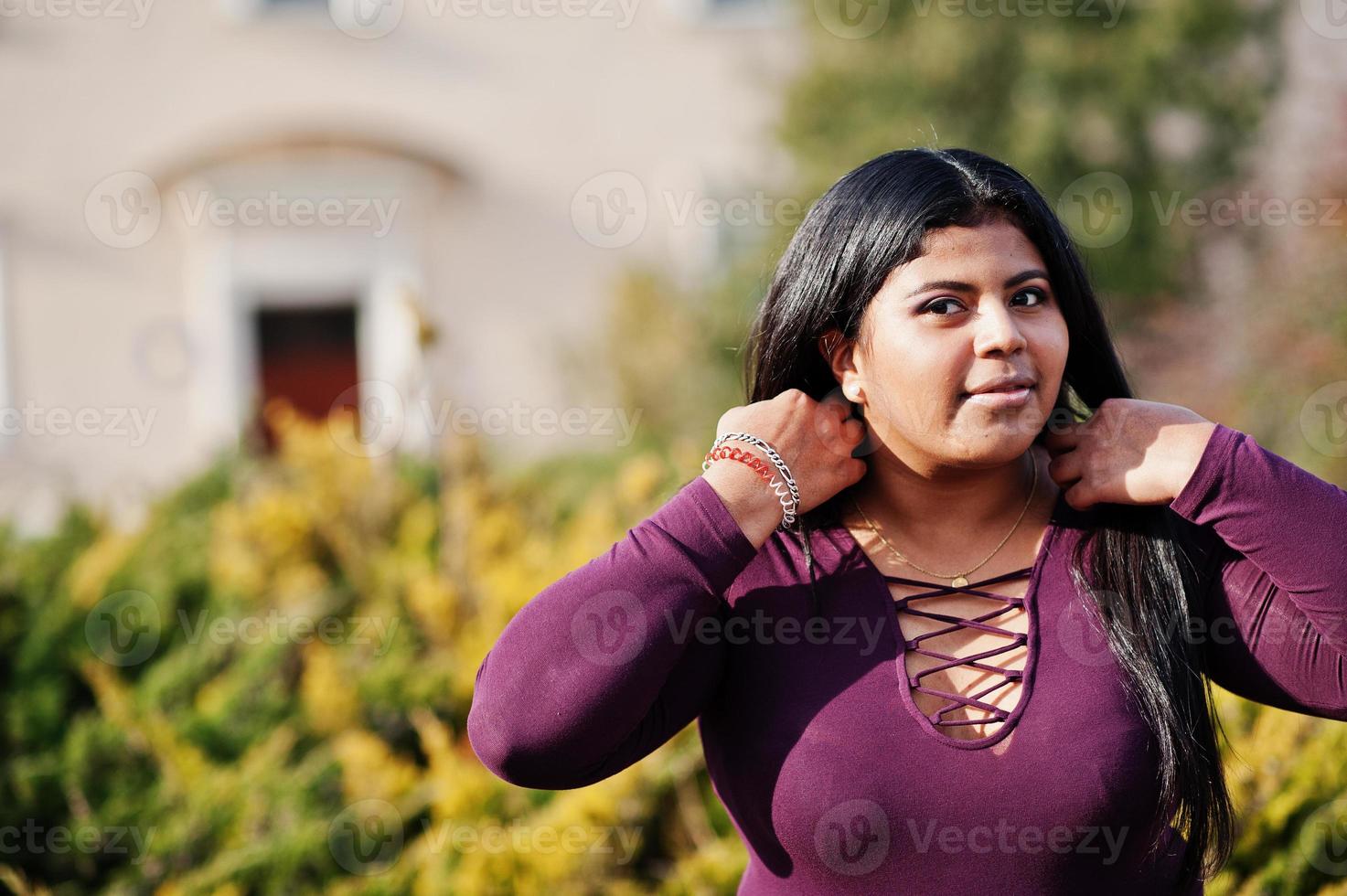 mooie latino xxl model meisje uit ecuador slijtage op violet blouse gesteld op straat. foto