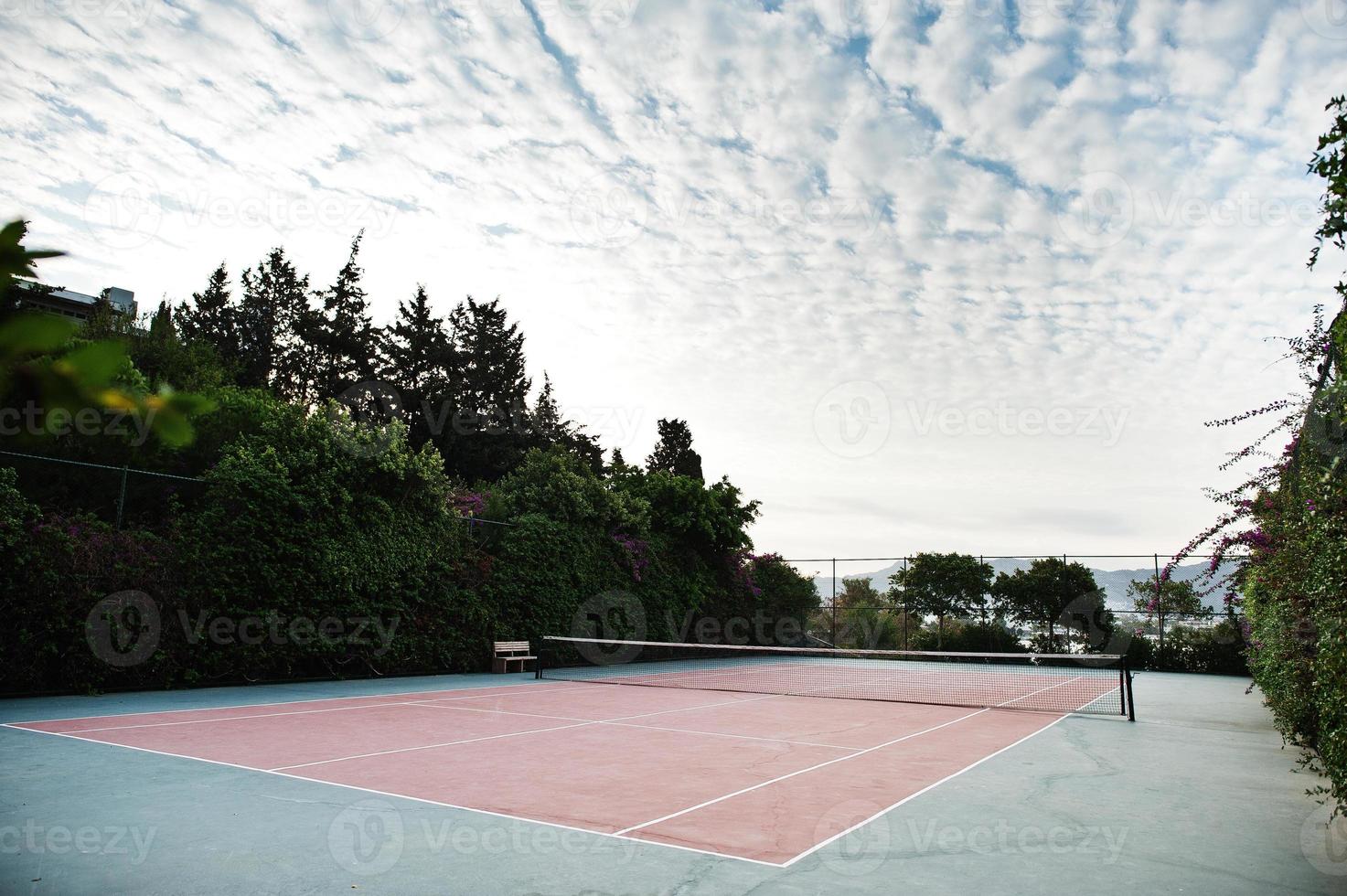 lege tennisbaan resort met bewolkte hemel. foto