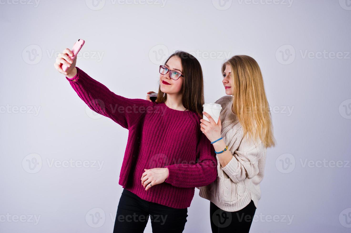 twee meisjes in paarse jurken die selfie nemen in de studio. foto