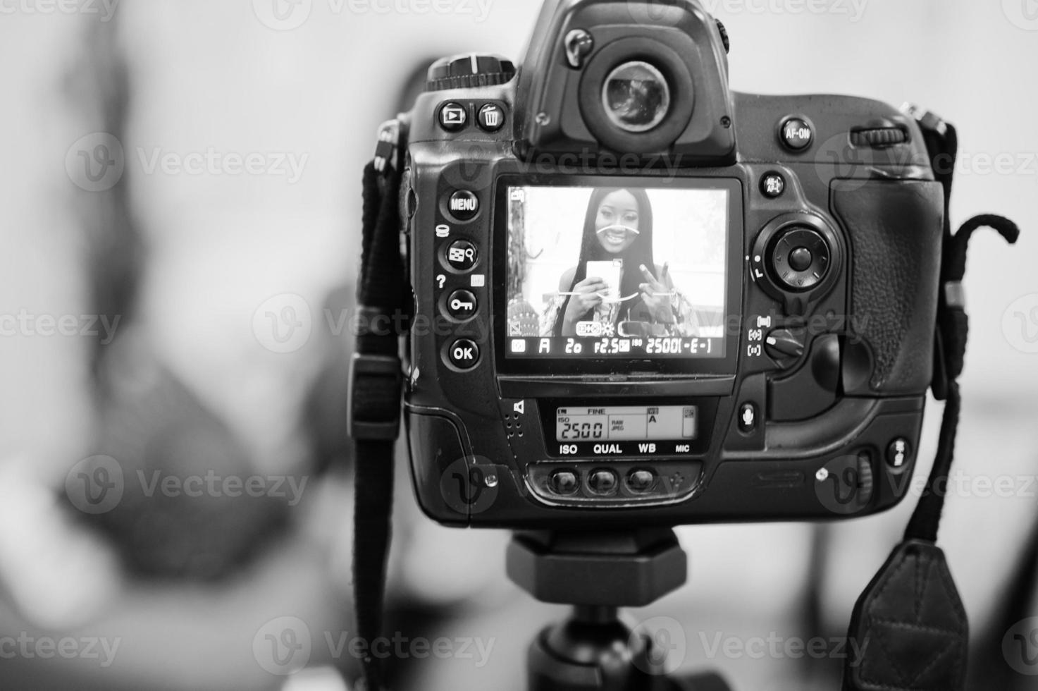 schattige Afro-Amerikaanse vrouw die een video maakt voor haar blog met behulp van een op een statief gemonteerde digitale camera. jonge vrouwelijke blogger of vlogger op camera. foto