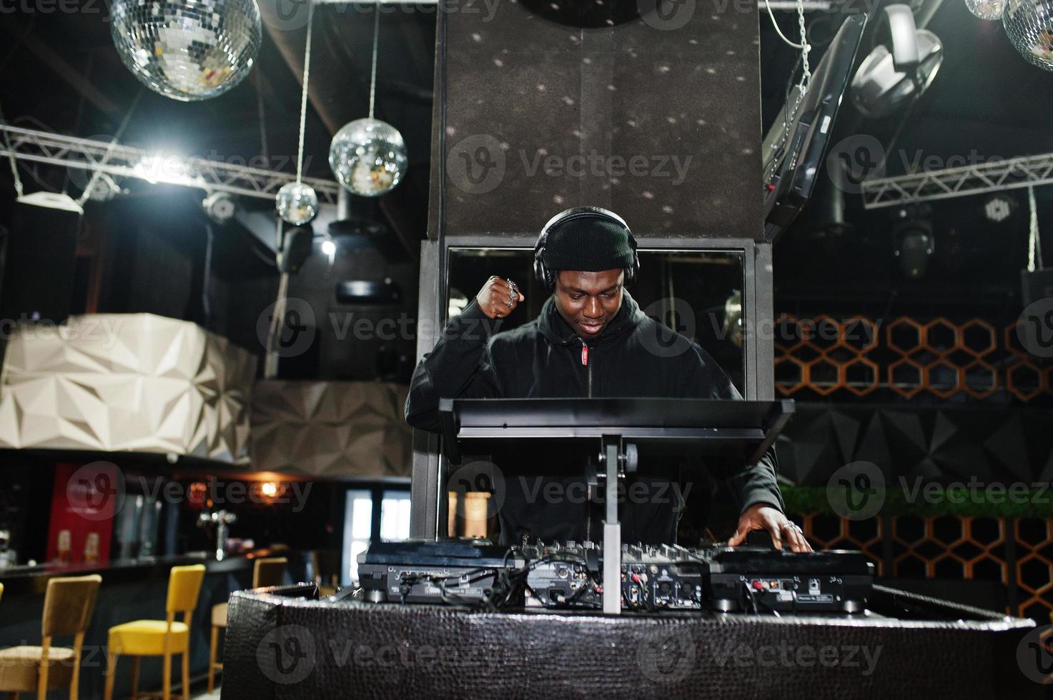 Afro-Amerikaanse dj speelt muziek op dekken in de nachtclub. foto