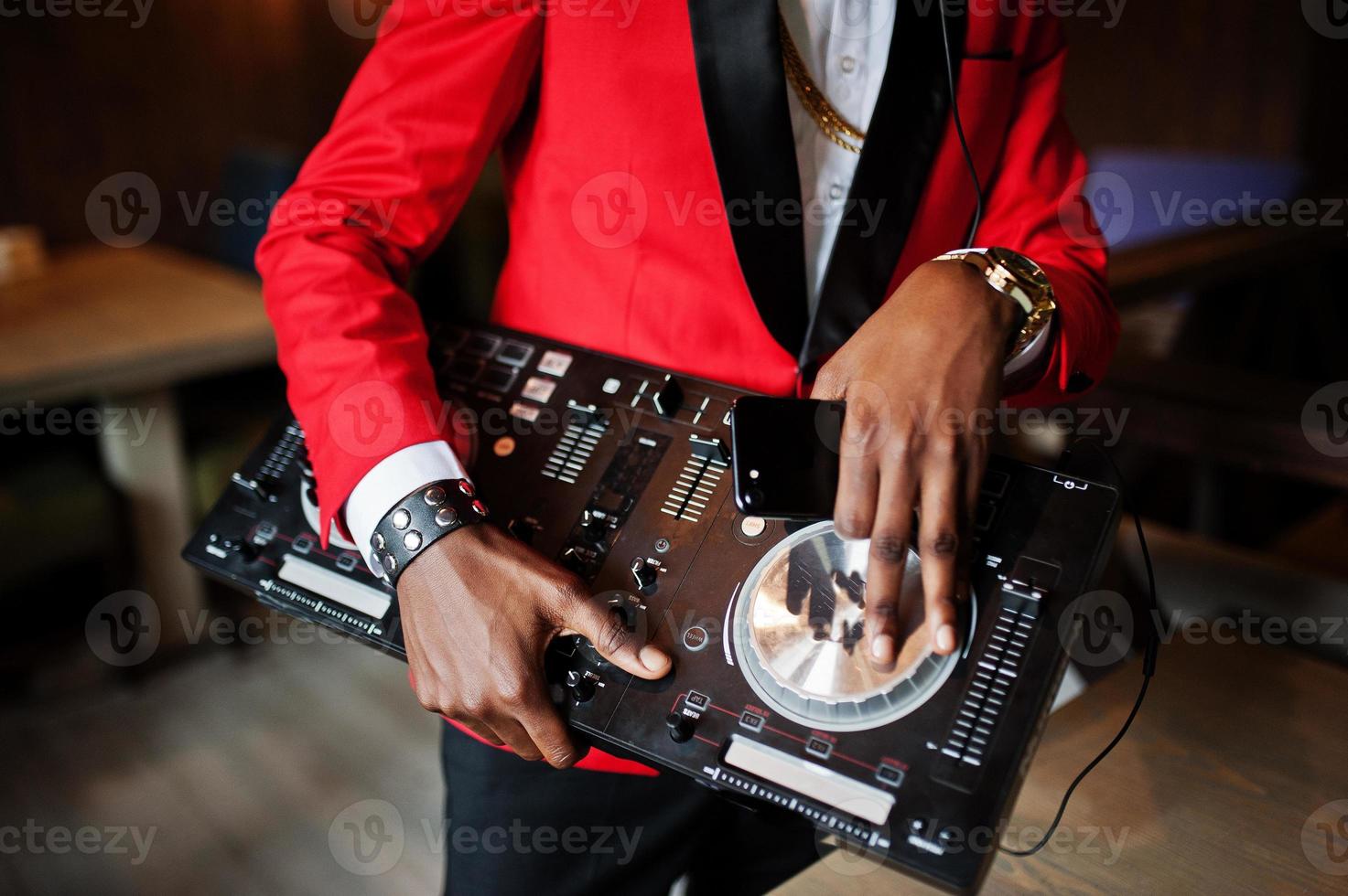 handen van mode Afro-Amerikaanse man model dj op rood pak met dj-controller. foto