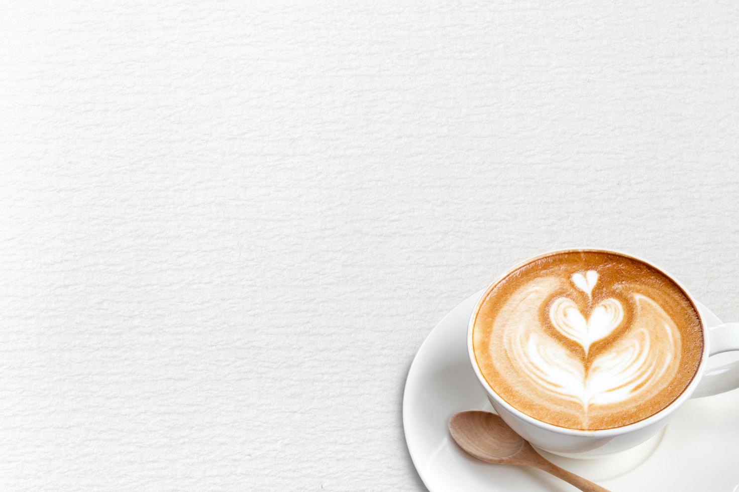 een kopje koffie latte met lepel op papier blackground foto