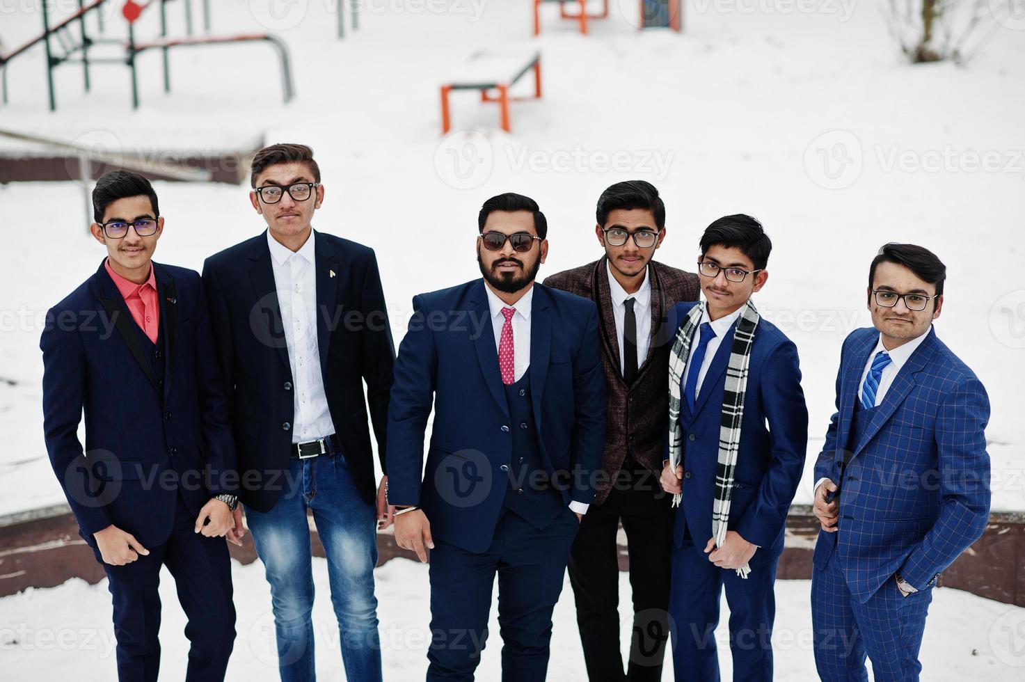 groep van zes Indiase zakenman in pakken poseerde buiten in de winterdag in europa. foto
