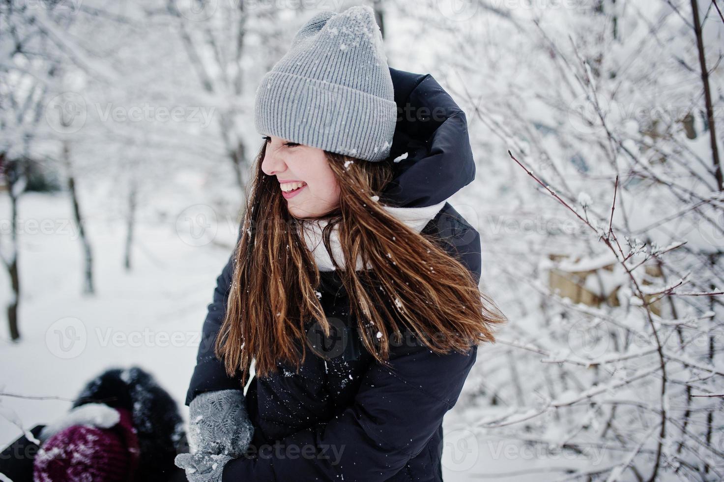 twee grappige meisjes vrienden plezier op besneeuwde winterdag in de buurt van besneeuwde bomen. foto