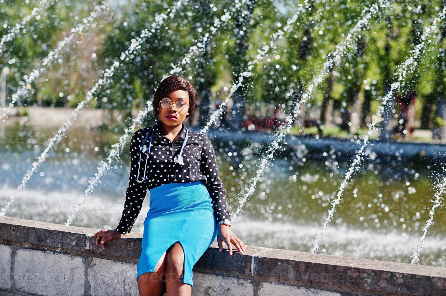 Afro-Amerikaanse dokter vrouw met stethoscoop poseerde buiten achtergrond fonteinen. foto