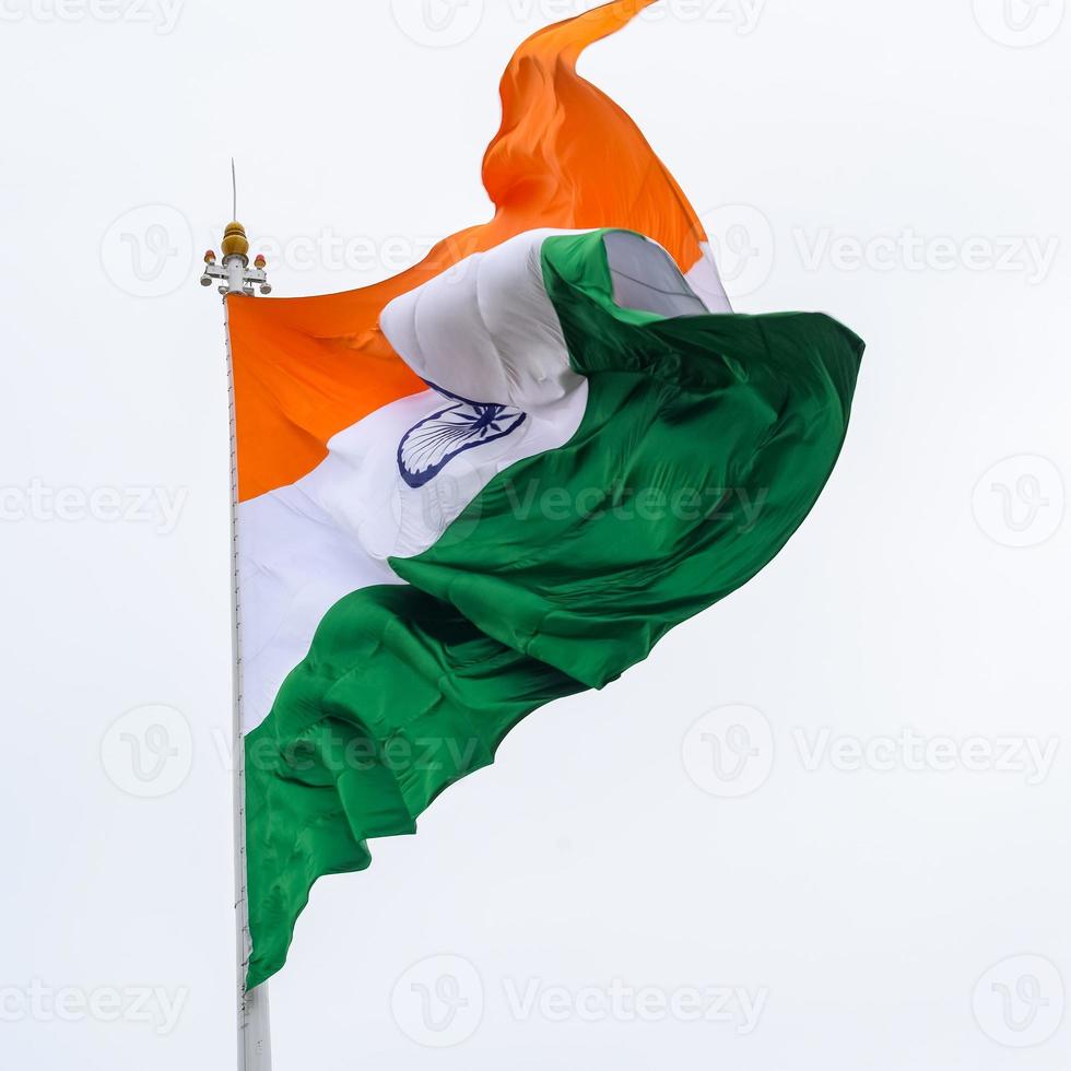 indiase vlag hoog op connaught plaats met trots in blauwe lucht, indiase vlag wapperen, indiase vlag op onafhankelijkheidsdag en republiek dag van india, tilt-up shot, wuivende indische vlag, har ghar tiranga foto