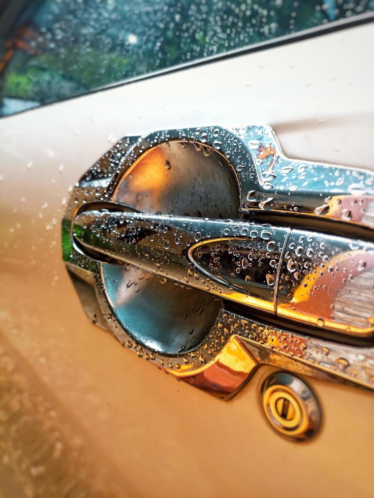 close-up regendruppels op de handgreep van een autodeur foto