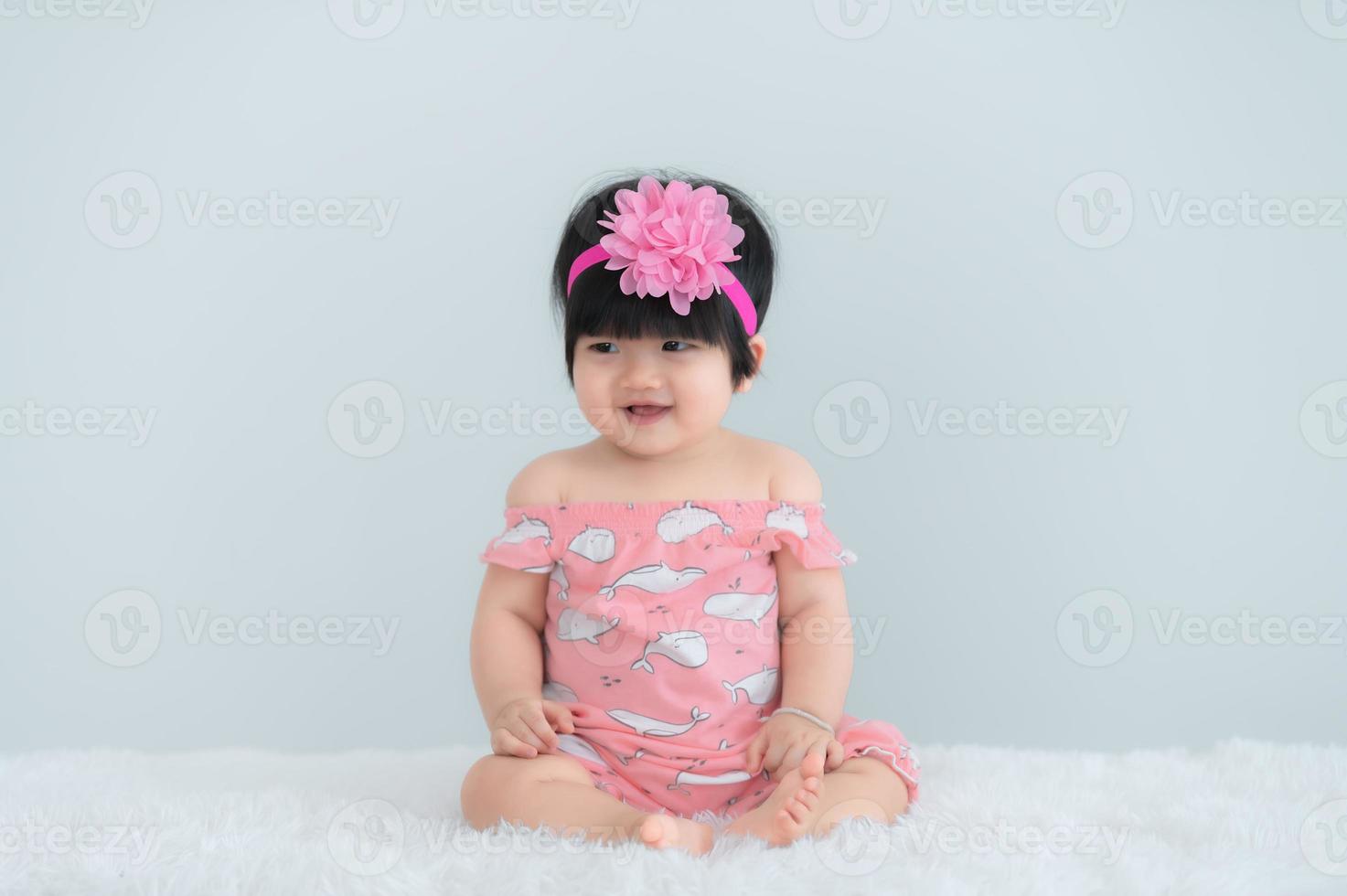portret van schattige Aziatische baby op wit tapijt, pasgeboren glimlach om een foto te maken